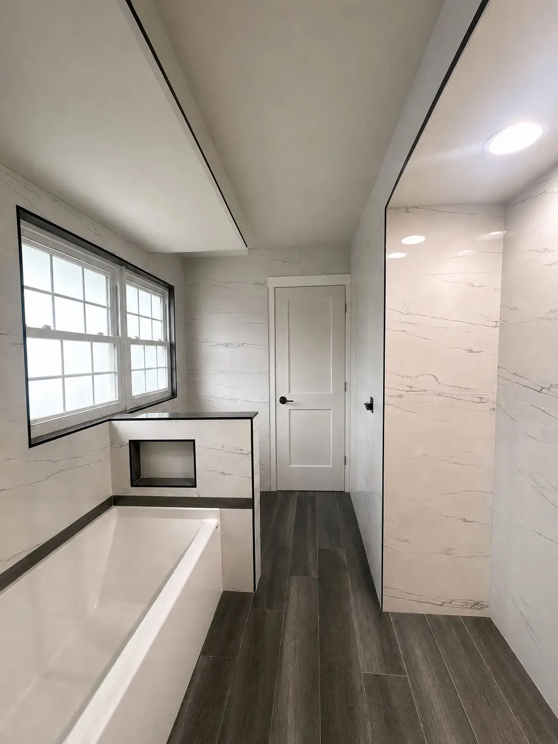 Bathroom with a built-in tub and walk-in shower finished in the same marble-look tile