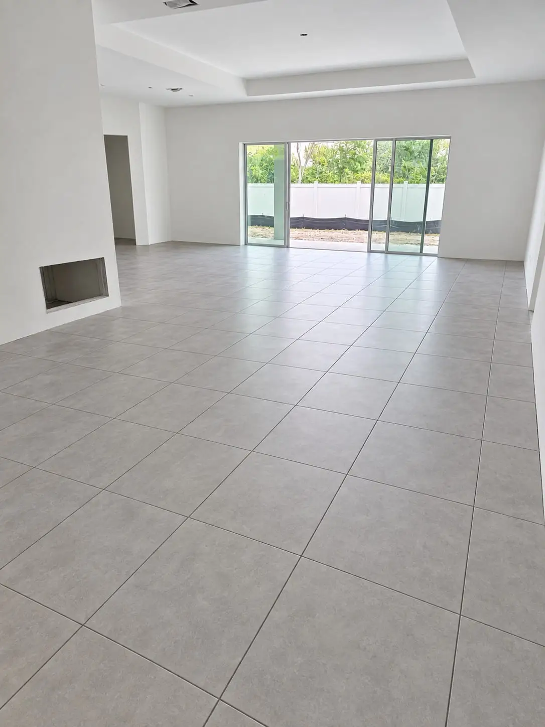 Open commercial space with a large-format grey porcelain floor laid on a straight grid