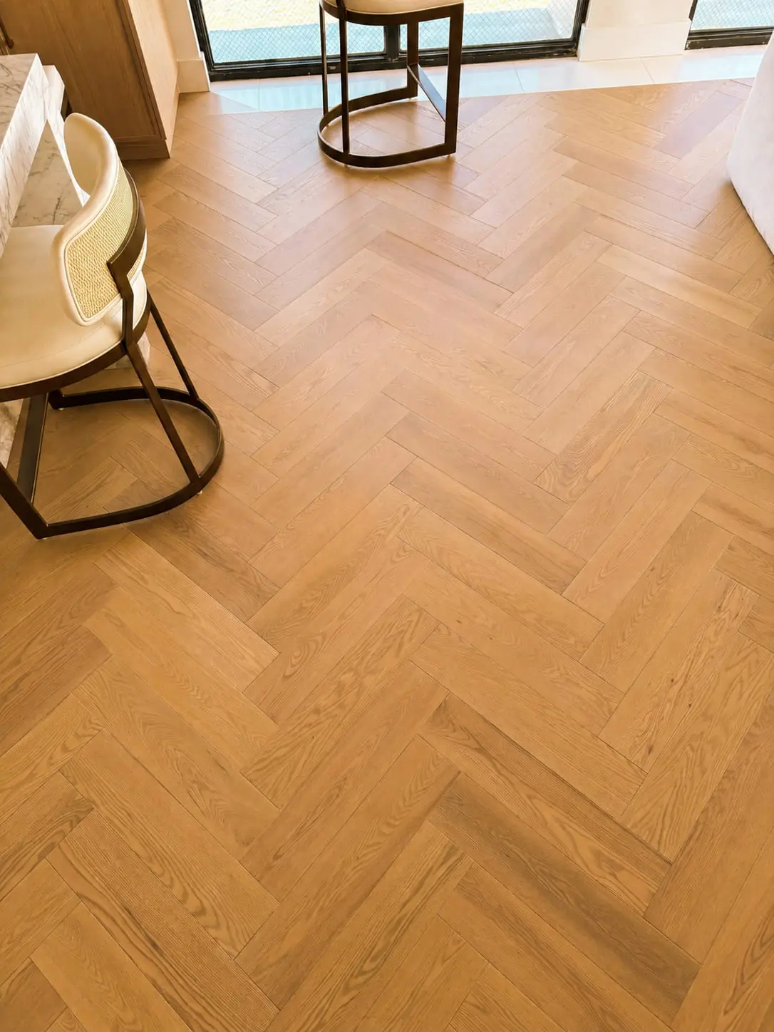 Oak herringbone floor running through a dining area with the points aligned along a single axis