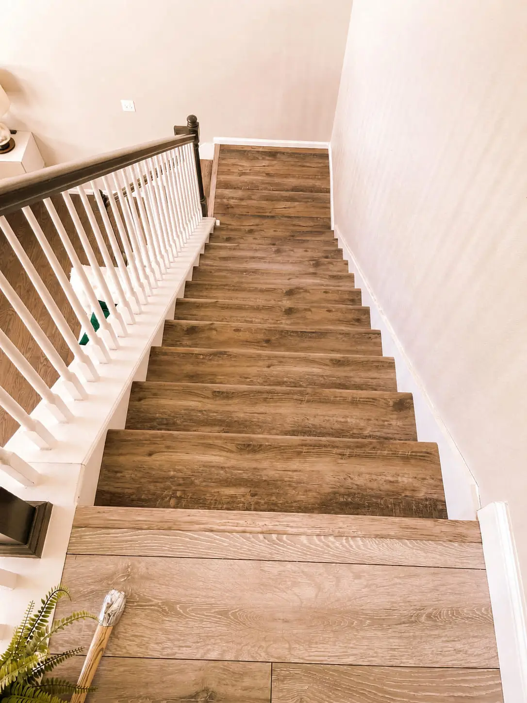 Wood stair treads and white risers running up to a turned balustrade